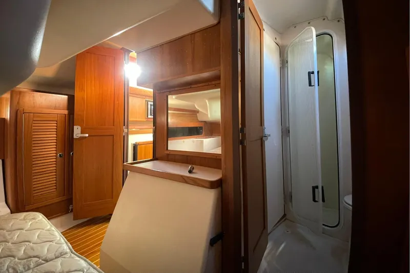 Slide: The Image of Interior of 2001 Catalina 380 sailboat featuring wooden cabinetry and compact bathroom. - 13