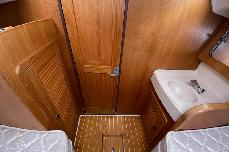 Slide: The Image of Interior of 2001 Catalina 380 sailboat with wooden cabinetry and compact sink. - 16