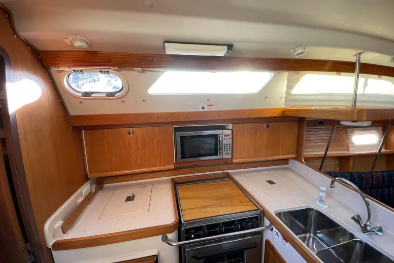 Slide: The Image of Interior of 2001 Catalina 380 sailboat kitchen with stove, microwave, and sink. - 17