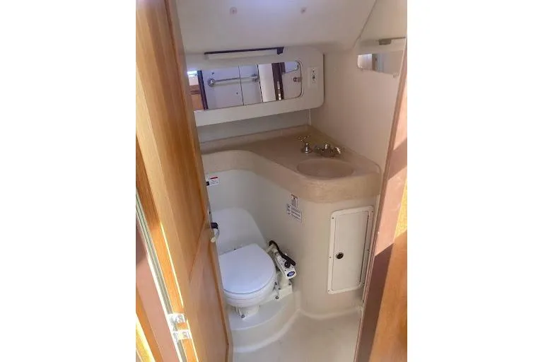 Slide: The Image of Bathroom interior of a 2001 Catalina 380 yacht, featuring a compact toilet and sink. - 18