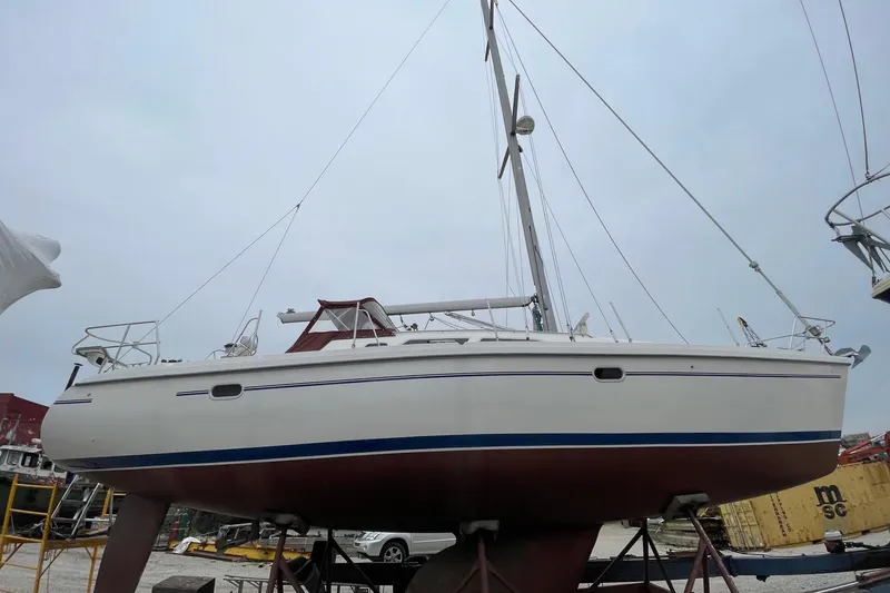 Slide: The Image of 2001 Catalina 380 sailboat on dry dock, showcasing hull and mast. - 3