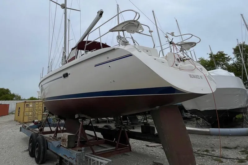 Slide: The Image of 2001 Catalina 380 sailboat on trailer in a boatyard, surrounded by shipping containers. - 4