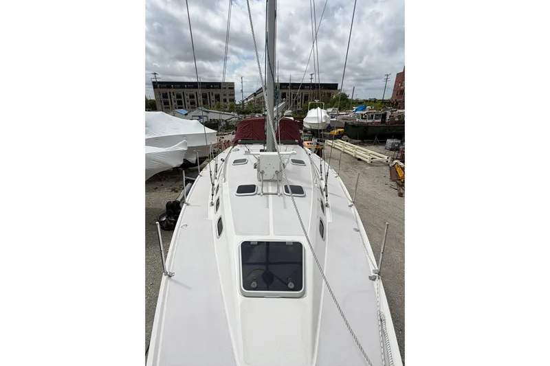 Slide: The Image of 2001 Catalina 380 sailboat deck view, docked in a marina under cloudy skies. - 7