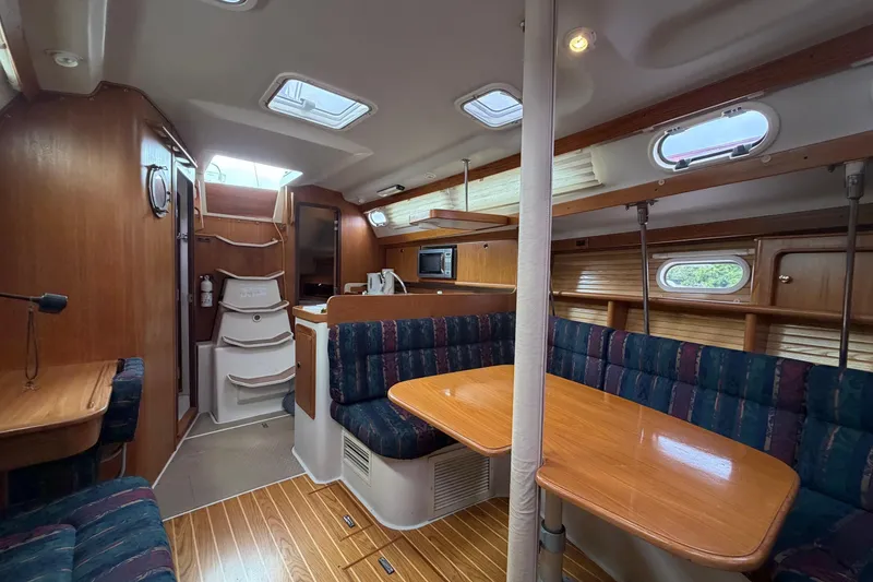 Slide: The Image of Interior of a 2001 Catalina 380 sailboat with wood finishes and cozy seating area. - 9