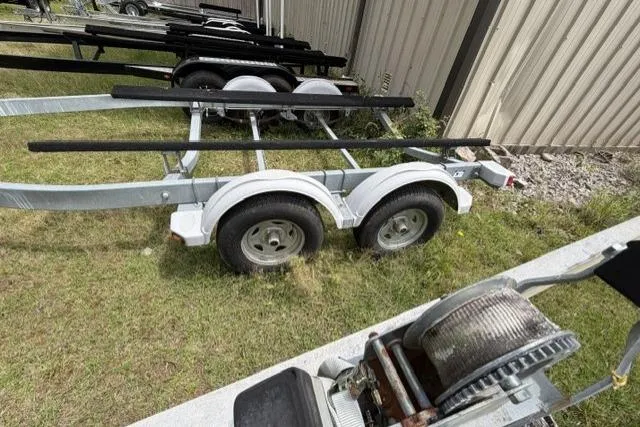 Slide: The Image of Boat trailer for 2007 Chaparral 236 SSi, parked on grass near a metal building. - 15