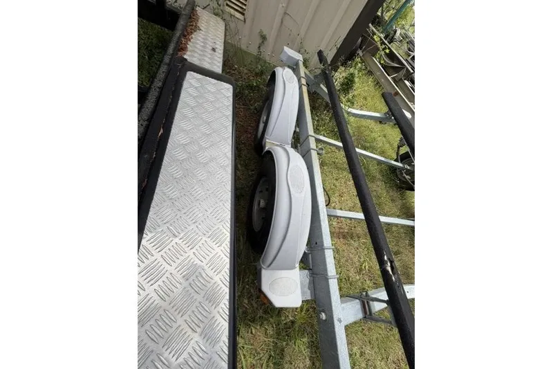 Slide: The Image of Trailer for 2007 Chaparral 236 SSi boat with metal fenders and grass background. - 16
