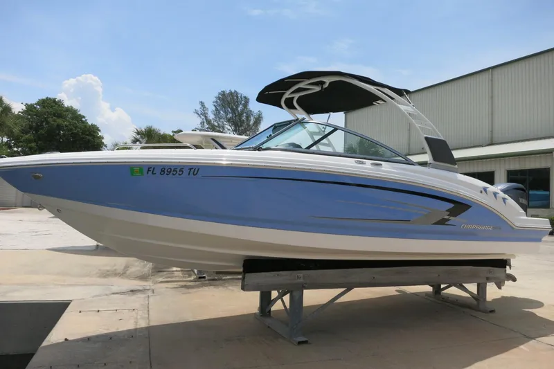 The Image of 2024 Chaparral 23 SSi OB boat in blue, displayed outdoors on a stand. - 0