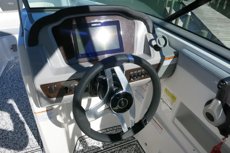 Slide: The Image of 2024 Chaparral 23 SSi OB boat dashboard with steering wheel and Simrad display. - 19