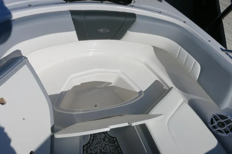 Slide: The Image of 2024 Chaparral 23 SSi OB boat interior with white seating and storage compartment. - 24