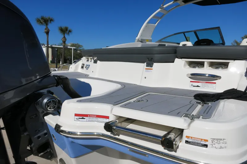 Slide: The Image of 2024 Chaparral 23 SSi OB boat rear deck with outboard motor and seating area. - 32