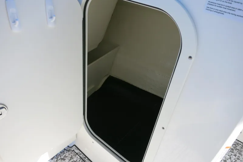 Slide: The Image of Storage compartment on a 2024 Chaparral 23 SSi OB boat, open door view. - 33