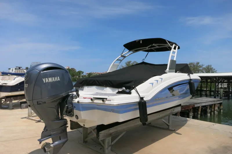 Slide: The Image of 2024 Chaparral 23 SSi OB boat with Yamaha outboard engine, docked under clear skies. - 35