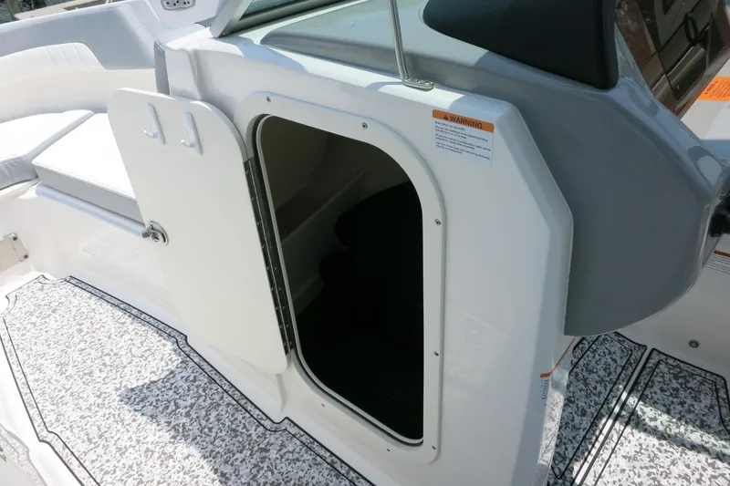 Slide: The Image of 2024 Chaparral 23 SSi OB boat interior storage compartment with open door. - 41