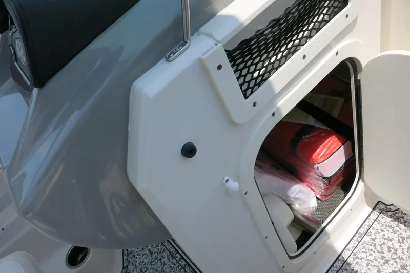 Slide: The Image of 2024 Chaparral 23 SSi OB boat storage compartment with safety equipment inside. - 42