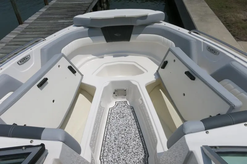 Slide: The Image of 2024 Chaparral 23 SSi OB boat interior with open storage compartments, dockside view. - 44