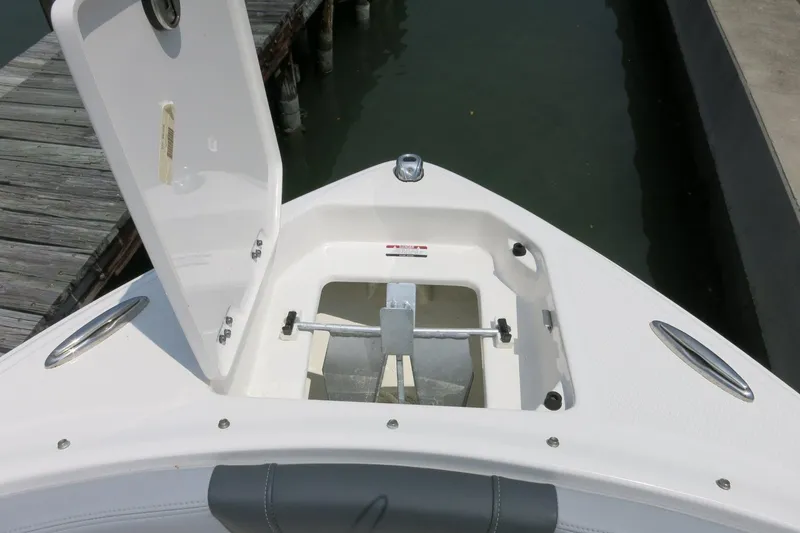 Slide: The Image of 2024 Chaparral 23 SSi OB boat anchor compartment open at dock. - 45