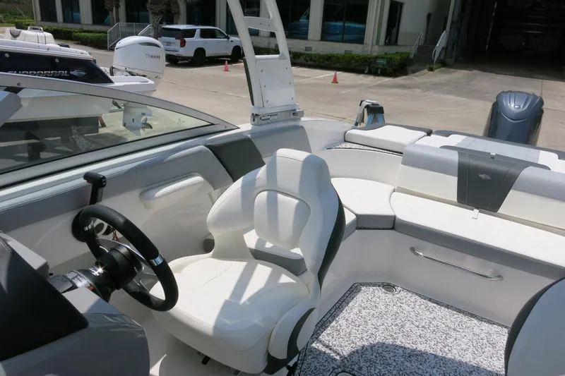 Slide: The Image of 2024 Chaparral 23 SSi OB boat interior with white seating and steering wheel. - 49