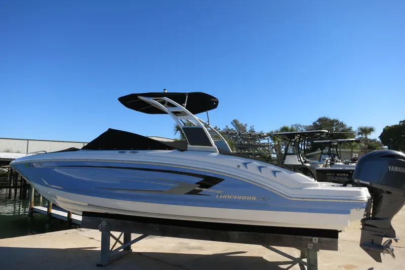 Slide: The Image of 2024 Chaparral 23 SSi OB boat with Yamaha outboard engine, docked under clear blue sky. - 5