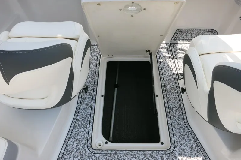 Slide: The Image of 2024 Chaparral 23 SSi OB boat interior with open storage compartment and cushioned seats. - 50