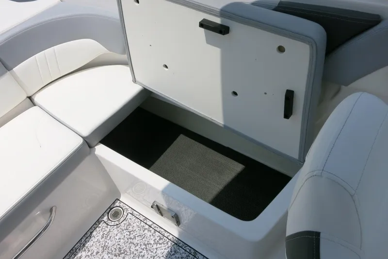Slide: The Image of 2024 Chaparral 23 SSi OB boat interior storage compartment with white seating. - 52