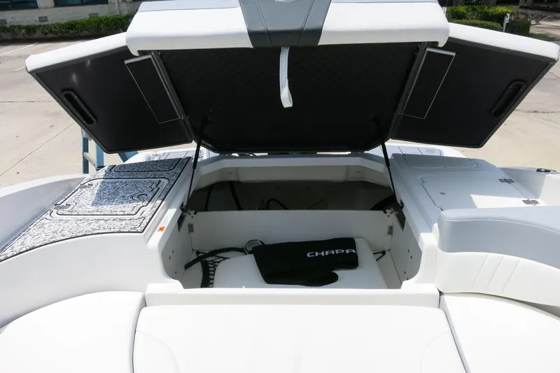 Slide: The Image of 2024 Chaparral 23 SSi OB boat with open storage compartment, showcasing sleek design. - 53