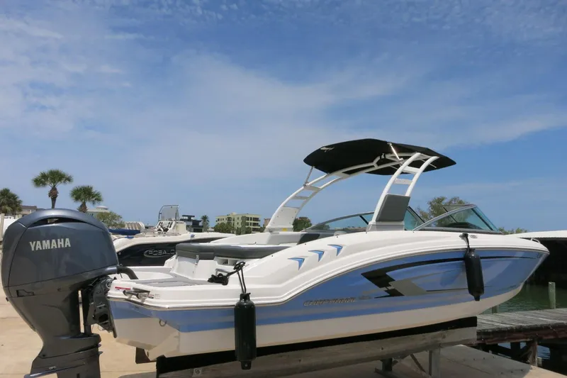 Slide: The Image of 2024 Chaparral 23 SSi OB boat with Yamaha outboard motor, docked under a clear blue sky. - 56