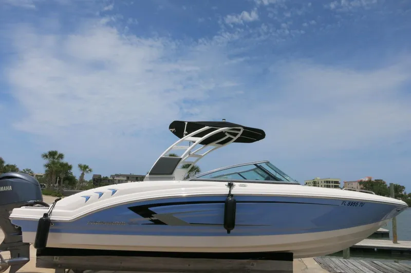 Slide: The Image of 2024 Chaparral 23 SSi OB boat docked under a clear blue sky. - 57