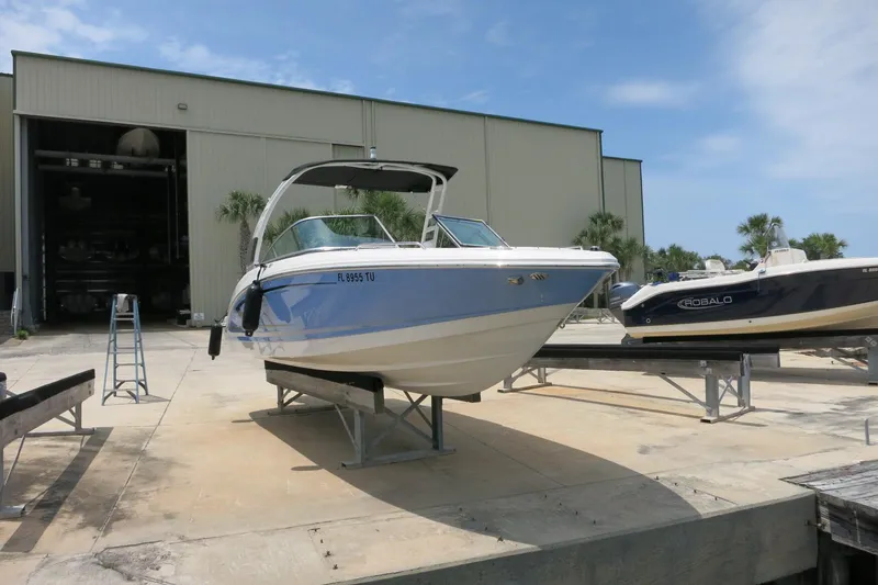 Slide: The Image of 2024 Chaparral 23 SSi OB boat on display outside a large storage facility. - 59