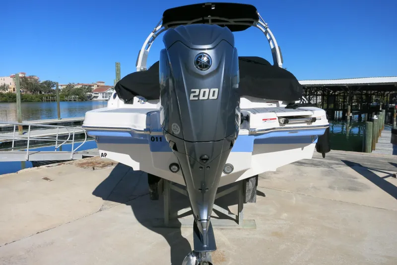 Slide: The Image of 2024 Chaparral 23 SSi OB boat with 200 HP outboard engine, docked by the water. - 7