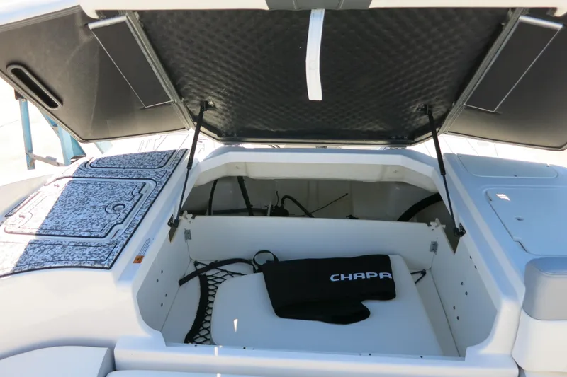Slide: The Image of 2024 Chaparral 23 SSi OB boat storage compartment with open hatch and accessories. - 9