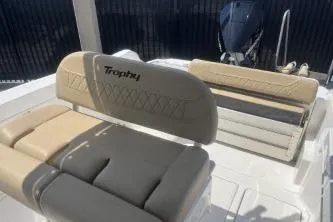 Slide: The Image of 2023 Trophy T24 CC boat interior with beige seating and motor. - 12