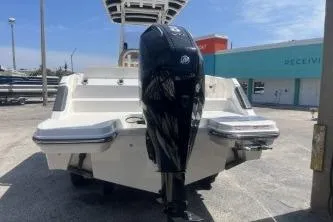 Slide: The Image of 2023 Trophy T24 CC boat with powerful outboard motor, docked outdoors. - 6