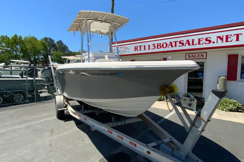 Slide: The Image of 2015 Tidewater 198 CC Adventure boat on trailer at dealership, sunny day. - 3