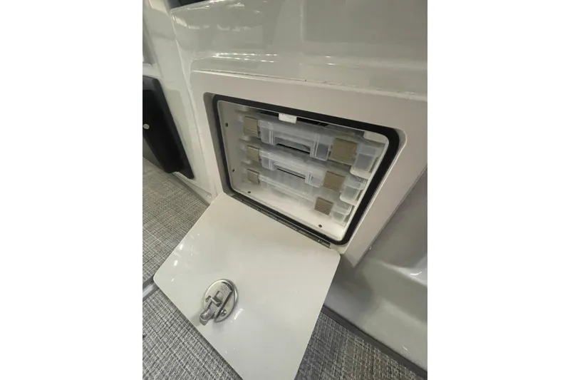 Slide: The Image of Storage compartment on 2022 Finseeker 280 DC boat, featuring organized tackle boxes. - 16