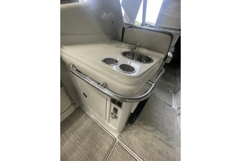 Slide: The Image of 2022 Finseeker 280 DC boat interior with sink and cup holders. - 25