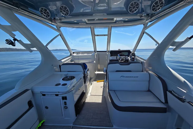 Slide: The Image of Interior of 2022 Finseeker 280 DC boat with seating and helm, on calm water. - 6