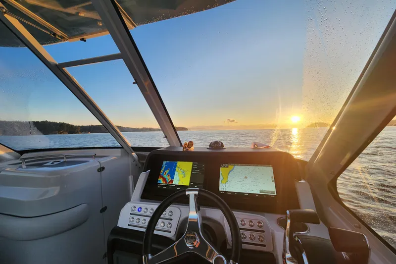 Slide: The Image of Cockpit view of 2022 Finseeker 280 DC boat at sunset on open water. - 8