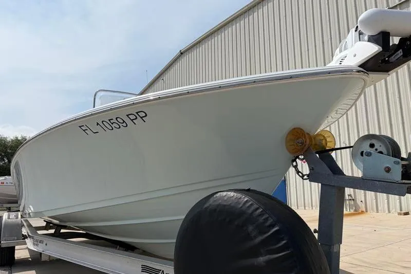 Slide: The Image of 2013 Sportsman Masters 207 Bay Boat on trailer, parked near a metal building. - 11