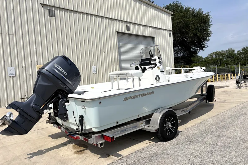 Slide: The Image of 2013 Sportsman Masters 207 Bay Boat with Yamaha engine on trailer near warehouse. - 2