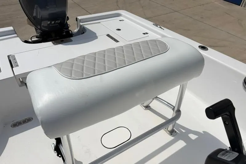 Slide: The Image of 2013 Sportsman Masters 207 Bay Boat interior with cushioned seating and motor. - 29