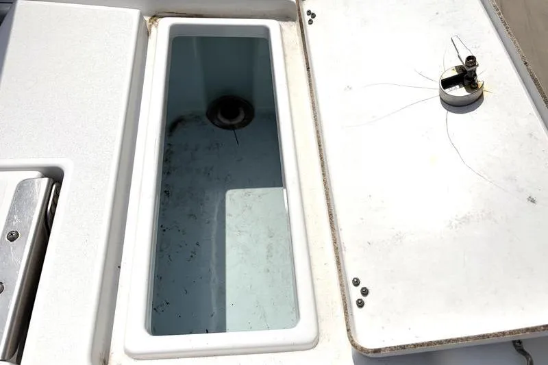 Slide: The Image of 2013 Sportsman Masters 207 Bay Boat storage compartment with open lid, showcasing interior details. - 38