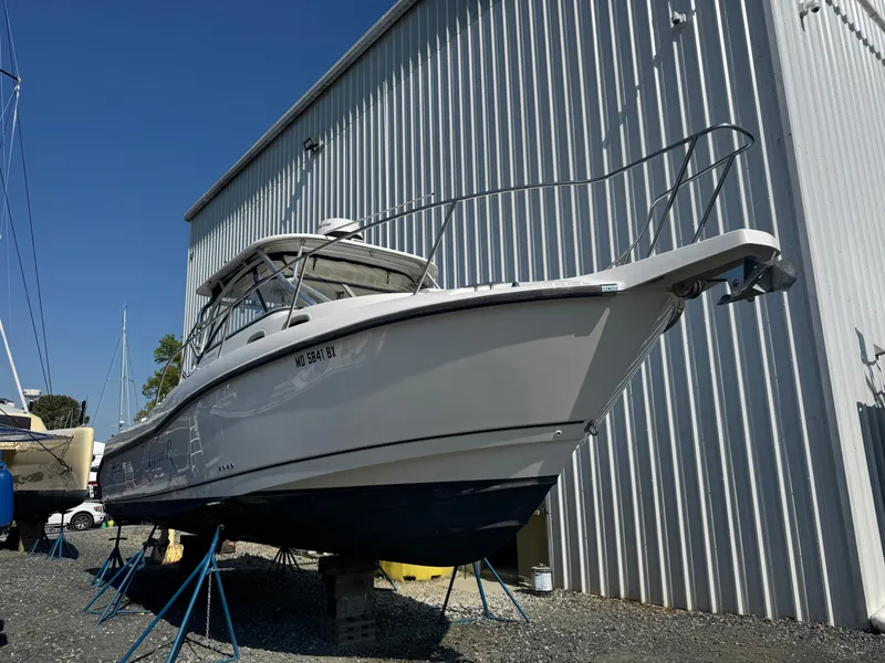 The Image of 2006 Boston Whaler 305 Conquest boat propped up outside warehouse. - 0