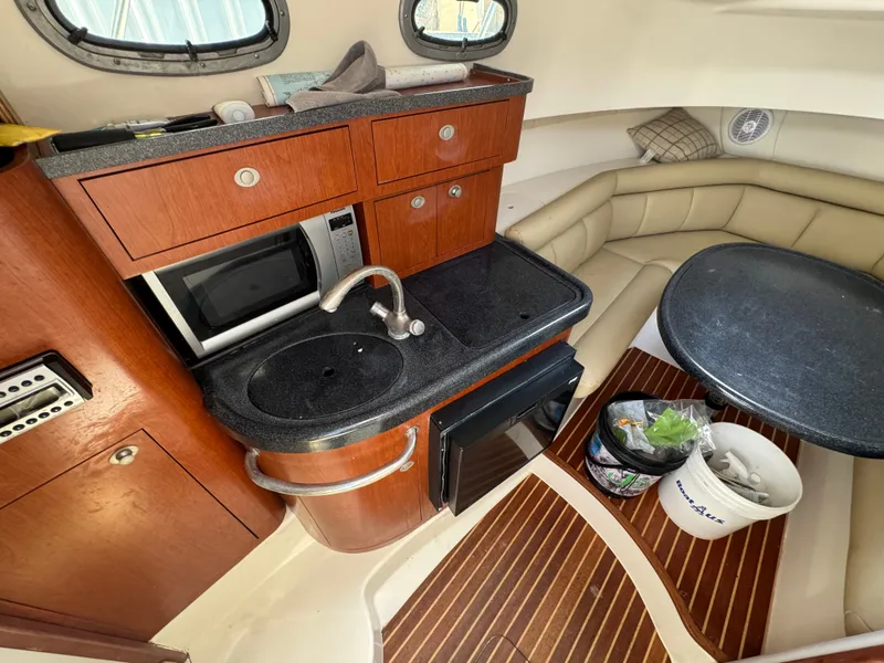 Slide: The Image of Interior of 2006 Boston Whaler 305 Conquest with kitchenette and seating area. - 25