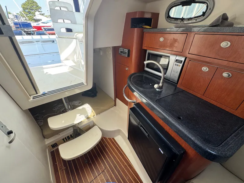 Slide: The Image of Interior of 2006 Boston Whaler 305 Conquest with kitchenette and stairs. - 27