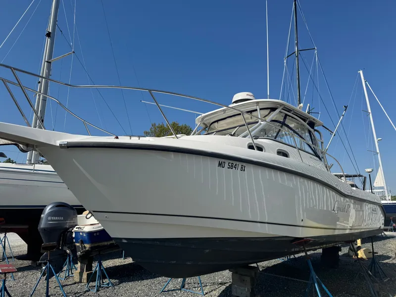 Slide: The Image of 2006 Boston Whaler 305 Conquest boat on stands outdoors. - 4
