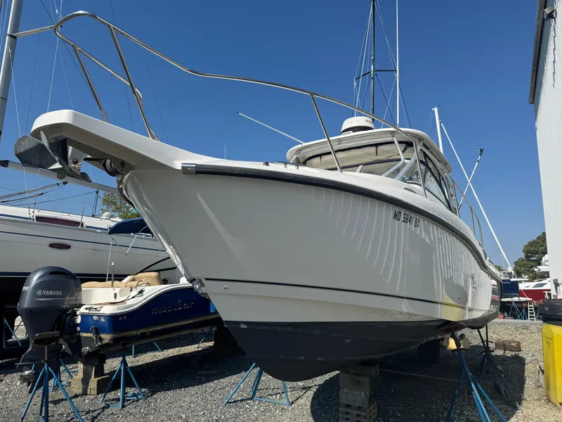 Slide: The Image of 2006 Boston Whaler 305 Conquest boat on stands outdoors. - 5