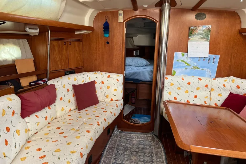 Slide: The Image of Cozy interior of 2004 Jeanneau Sun Odyssey 40 sailboat with floral upholstery and wooden finishes. - 3