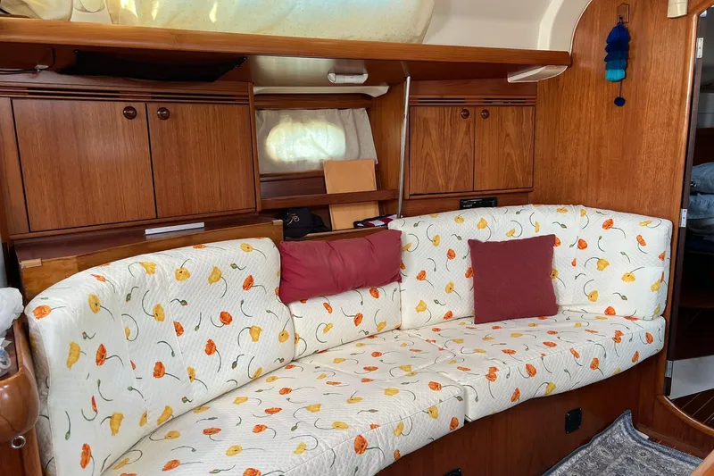 Slide: The Image of Interior of 2004 Jeanneau Sun Odyssey 40 with floral-patterned seating and wooden cabinetry. - 4