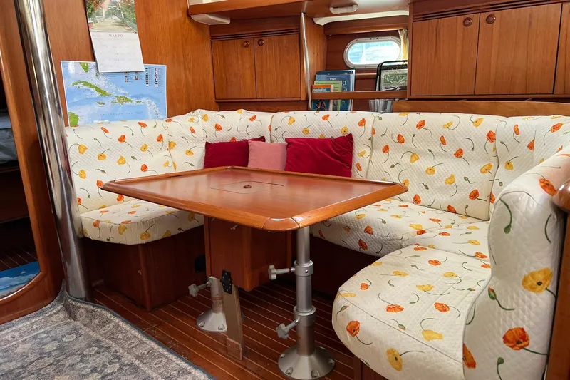 Slide: The Image of Cozy interior of 2004 Jeanneau Sun Odyssey 40 with floral upholstery and wooden table. - 5