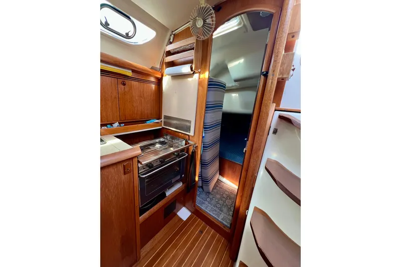 Slide: The Image of Interior of 2004 Jeanneau Sun Odyssey 40 sailboat, featuring a compact kitchen and cozy cabin. - 6